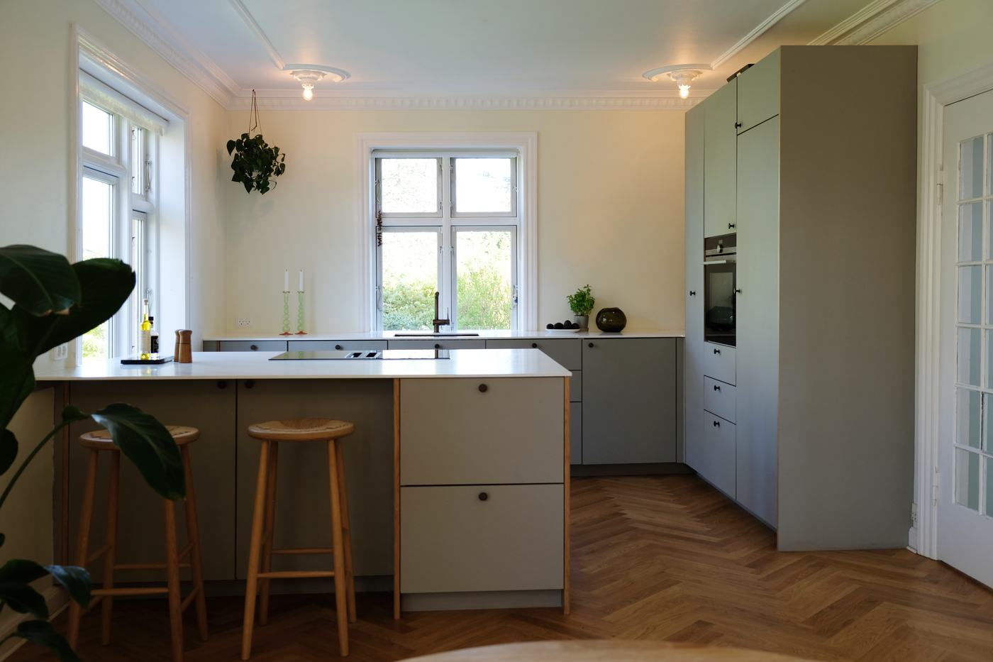 Køkken med matte grågrønne fronter og køkkenø